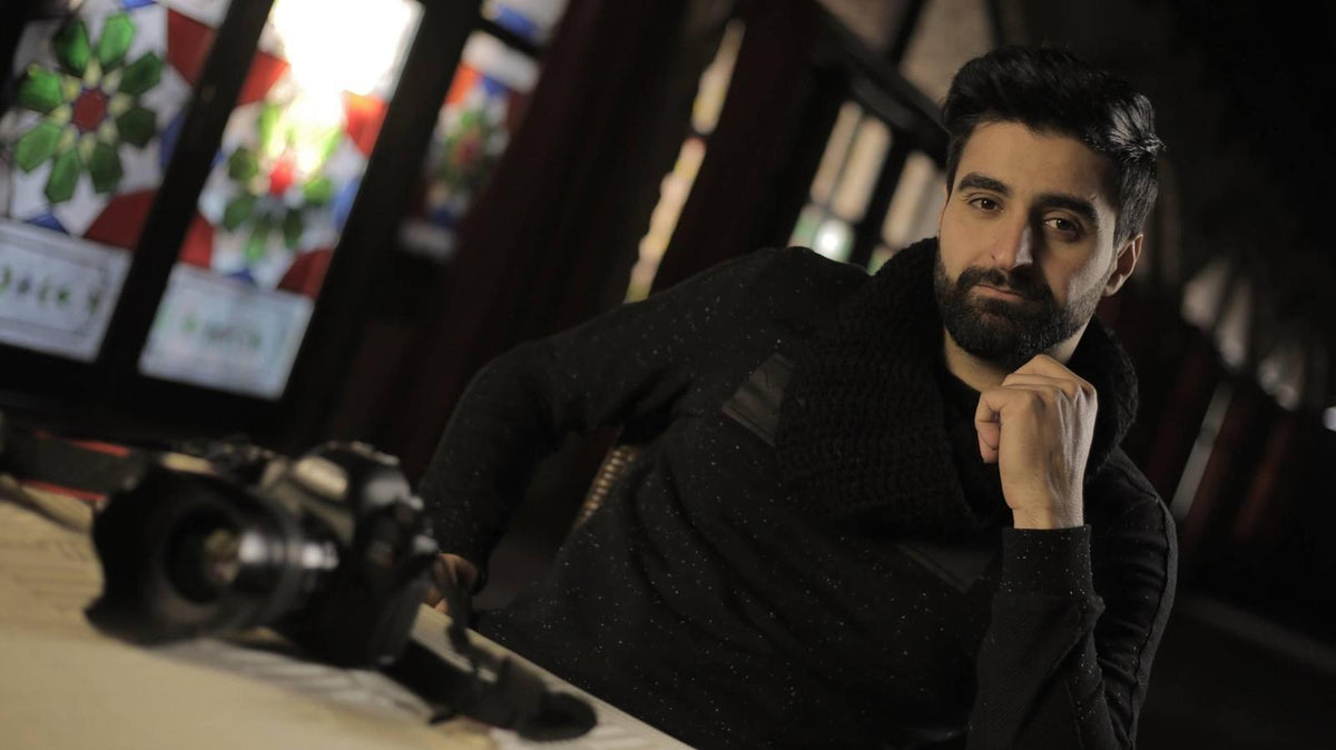 Portrait of photographer Wissam Nassar seated with his camera